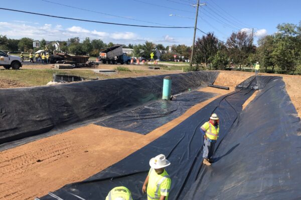 Crew members standing in a tarped dirt green infrastructure element.