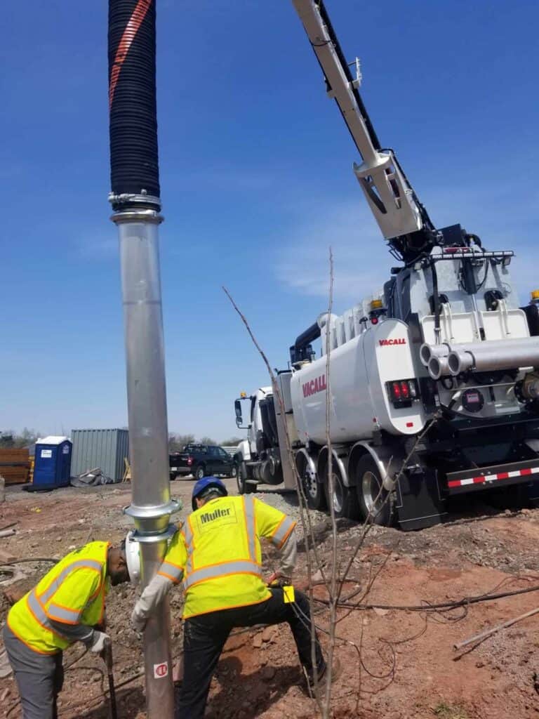 Muller Inc. employees working on a vacuum excavation site with machinery